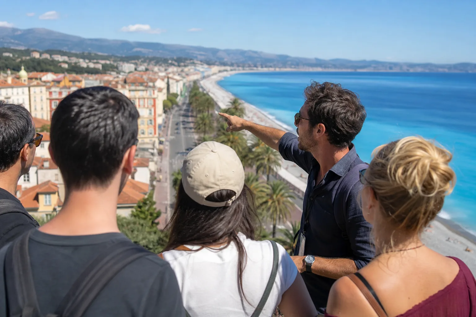Un guide montre la baie de Nice à un petit groupe de voyageurs depuis la colline du Château